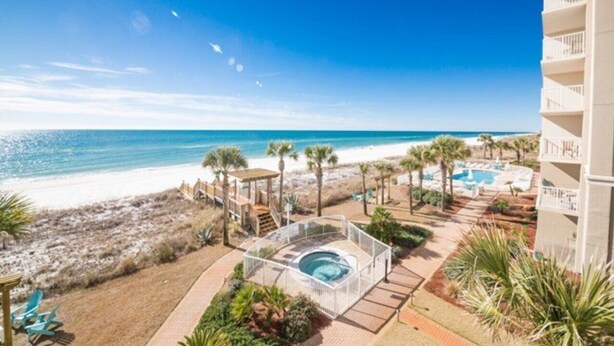 Hotel aan het strand met een zwembad, een jacuzzi en uitzicht op het strand.