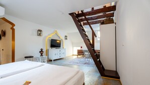 A bedroom with a bed, a TV, a white dresser, a small table, and a chair. - "Suite Marrakesch" with King-Size Bed and Air Conditioning (Gengenbach)