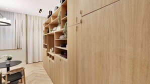 Una habitación moderna con un armario de madera, una mesa redonda y una silla.