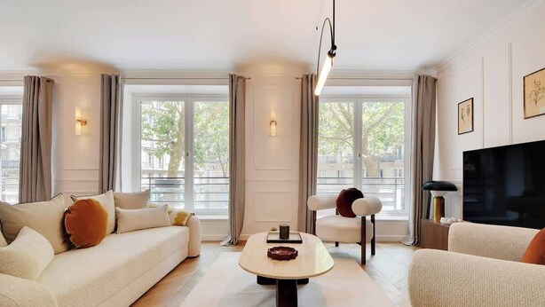 A modern living room with a sofa, armchairs, a coffee table, and a TV. - ONIRI - Somptuous Serviced 3-BR - Saint-Germain (Paris)