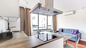 Uma cozinha moderna com fogão embutido, torradeira e janela com cortinas.