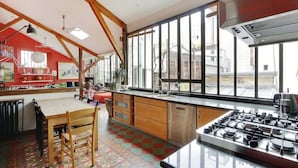 A kitchen with a large island, wooden cabinets, and a gas stove.