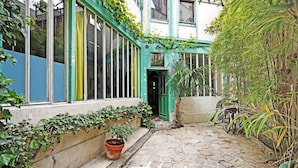 A courtyard with a stone pathway, a bicycle, and potted plants.