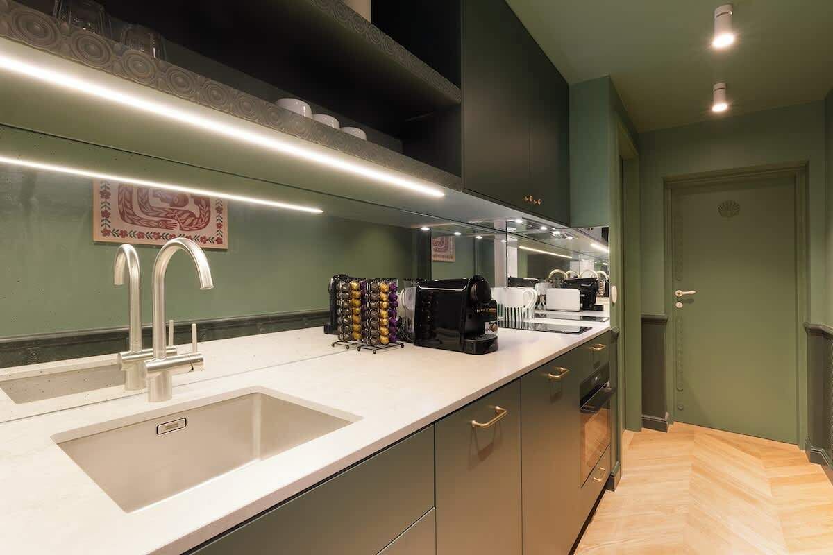 A modern kitchen with a white countertop, stainless steel appliances, and a built-in oven.