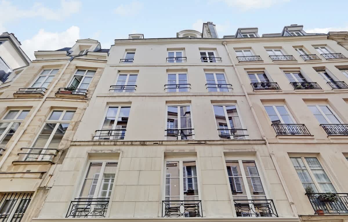 Un edificio de varios pisos con un estilo arquitectónico clásico, con balcones y ventanas amplias.