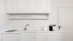 A white kitchen with a built-in oven, a coffee maker, and a toaster on the countertop. - French Chic Apartment in Saint Germain #1 (Paris)