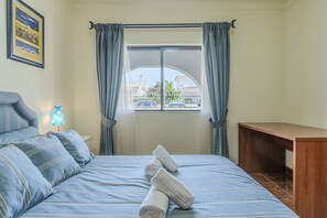 A hotel room with a bed, a desk, and a window with curtains. - #350 Quiet Retreat for Families | Relax & Nature (Ferreiras)