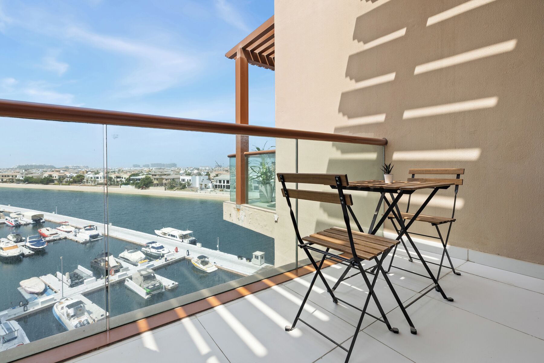 A balcony with a view of a marina and cityscape.
