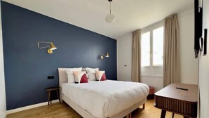 Ein Schlafzimmer mit einem Bett, Nachttischen und einem Schreibtisch.