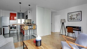 Una sala moderna con una mesa de centro de madera, sofá gris y una zona de comedor con sillas.