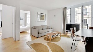 Ein modernes Wohnzimmer mit Sofa, Couchtisch und Fernseher.