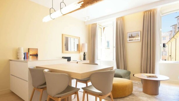 Un salon moderne comprenant un coin repas, un canapé et une table basse ronde.