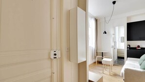 Ett modernt, minimalistiskt sovrum med en stor säng, sängbord och en garderob.