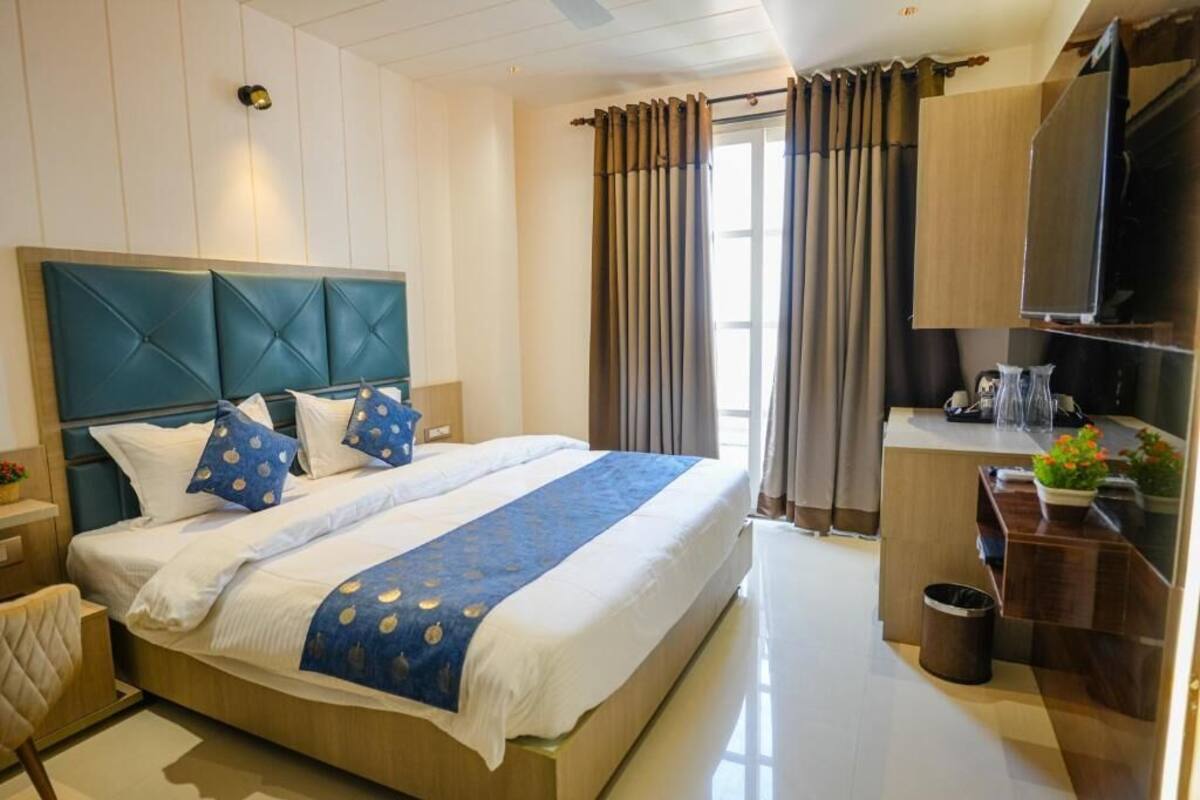 Una habitación de hotel moderna con una cama grande, un escritorio y una televisión.