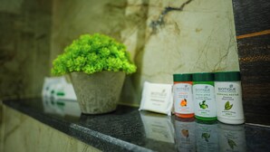A countertop with a potted plant, Biotique products, and a Biotique-branded item. - Sri Shyam Villas (VARANASI)