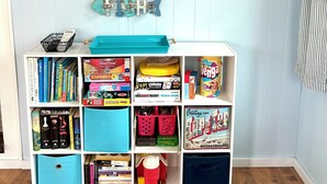 Een boekenplank met een bord erboven met de tekst 'THE BEACH HOUSE'.