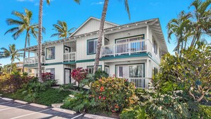 A two-story hotel with a balcony on the second floor, surrounded by tropical vegetation. - Regency at Poipu Kai 123 By Parrish Kauai - Short walk to Beach (Koloa)