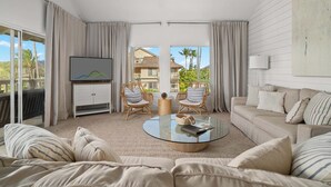 A modern living room with a sofa, two armchairs, a coffee table, and a TV. - Regency at Poipu Kai 123 By Parrish Kauai - Short walk to Beach (Koloa)