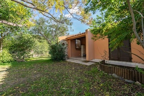 A house with a covered porch, a stone wall, and a fenced yard.