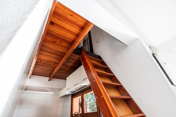 A wooden staircase with a view of a window and a door leading to a room.