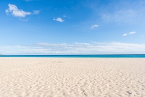 A beach with a clear sky and calm sea.