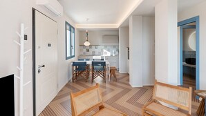 Un interior moderno con comedor, cocina y un pasillo que conduce a un dormitorio.