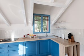 A kitchen with blue cabinets, a wooden countertop, a window with blue trim, and a sink. - Apartment 'Verde Mare' with Sea View, Private Terrace and Wi-Fi (Andora)