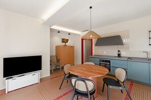 A modern kitchen with a large TV, dining table, and chairs. - Apartment 'Corallo' with Sea View, Private Terrace and Wi-Fi (Andora)