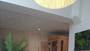 A breakfast setup with croissants, oranges, bananas, and juice on a table, a potted plant, and a shower area in the background. - Wellness Suite with Jacuzzi & Sauna, Premium Comfort in City Center (Quimper)