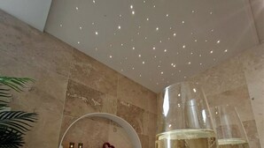 A bathtub with rose petals, two champagne glasses, a heart-shaped decoration, and a plant. - Wellness Suite with Jacuzzi & Sauna, Premium Comfort in City Center (Quimper)