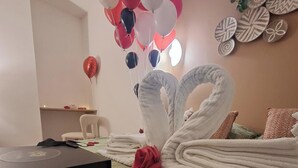 A room with a bed, a box on the floor, and a wall with decorative plates. - Wellness Suite with Jacuzzi & Sauna, Premium Comfort in City Center (Quimper)