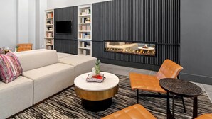 Ein modernes Wohnzimmer mit einer Eckcouch, einem runden Couchtisch und einem Kamin.