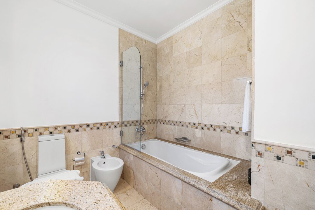 Een badkamer met een bad, toilet en bidet.