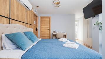 Um quarto com uma cama, uma escrivaninha, uma cadeira e uma televisão.