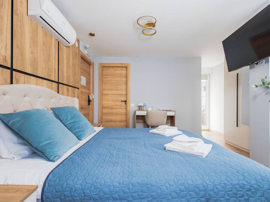 Um quarto com uma cama, uma escrivaninha, uma cadeira e uma televisão.