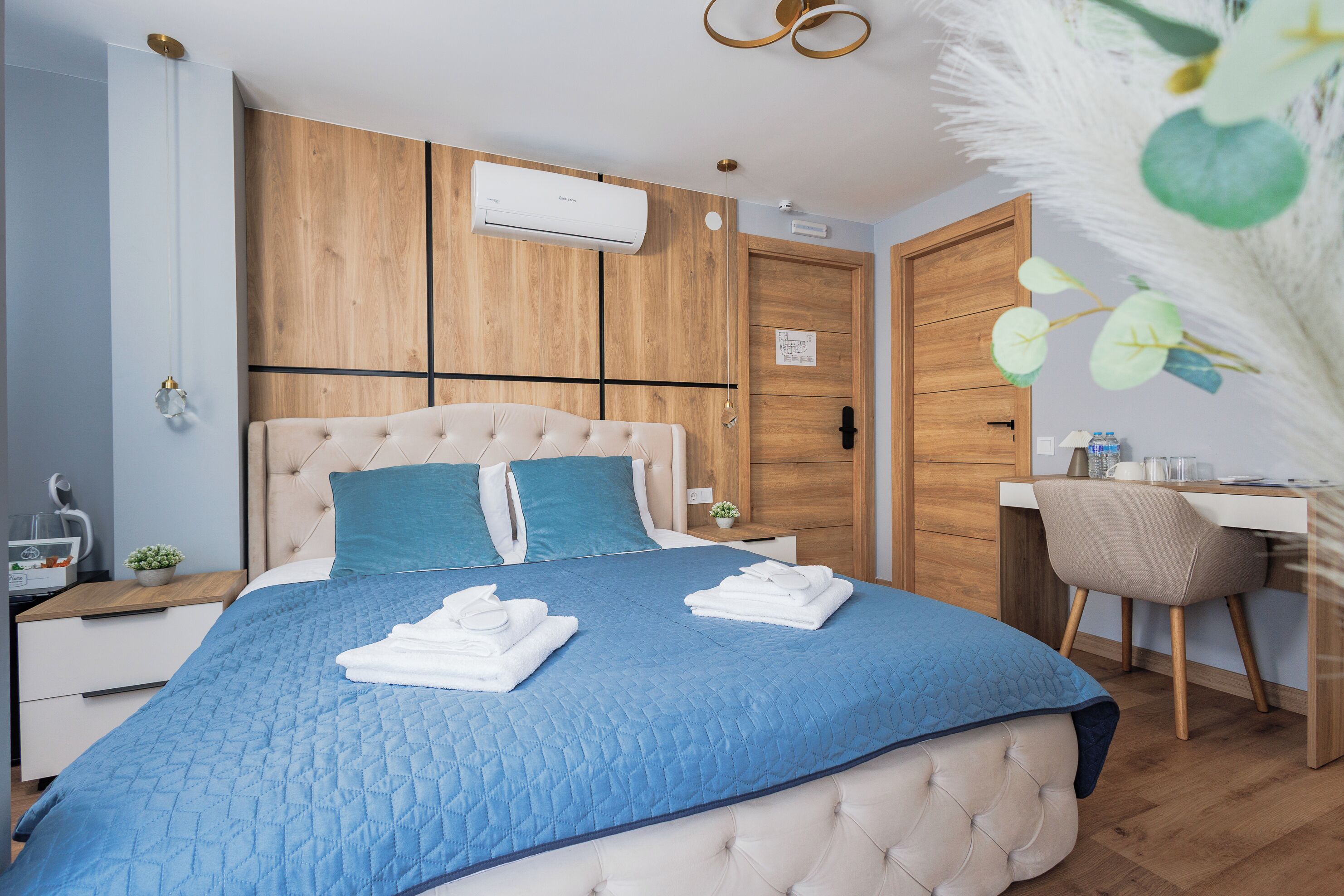 Un dormitorio con cama, escritorio, silla y equipo de aire acondicionado.