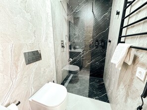 Habitación estándar | Baño | Regadera, pantuflas, toallas, jabón 