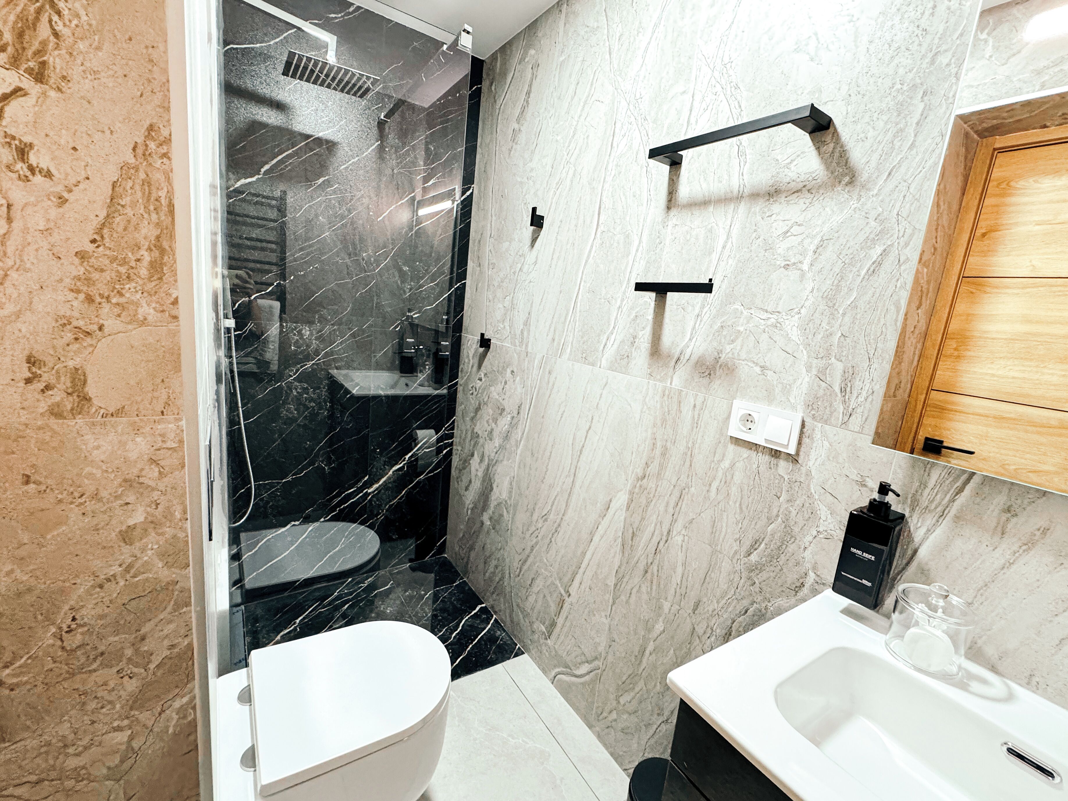 A modern bathroom with a toilet, sink, and shower area.
