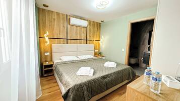 Een hotelkamer met een bed, nachtkastje en een houten hoofdbord.