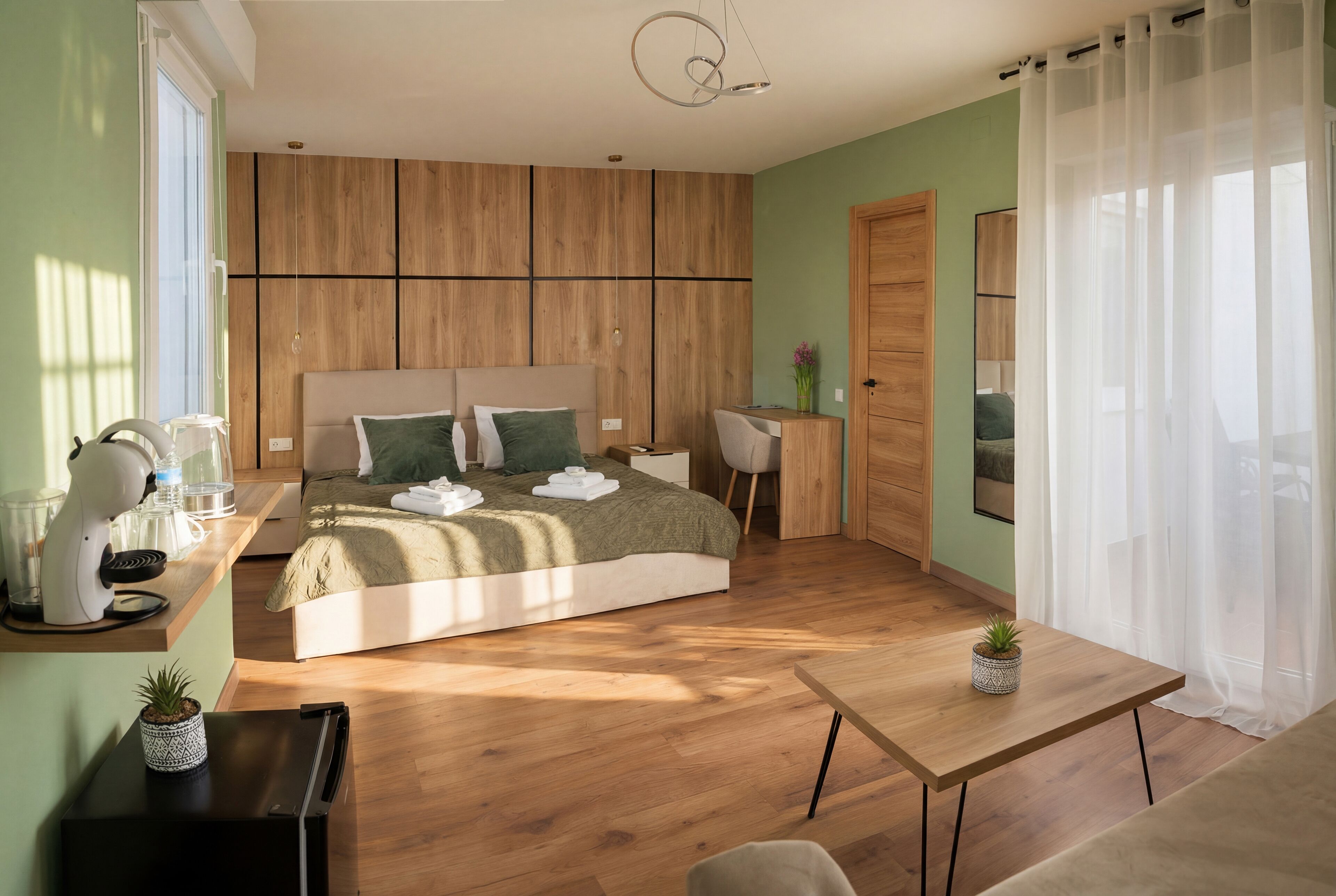 A modern bedroom with a bed, bedside table, and a desk with a chair.