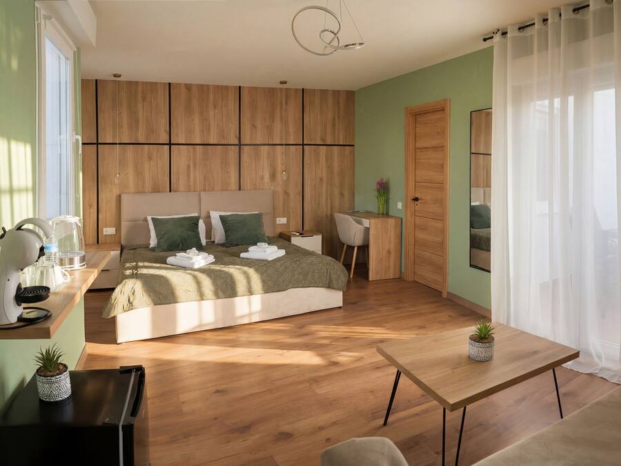 A modern bedroom with a bed, bedside table, and a desk with a chair.