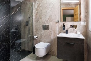 Luxe kamer | Badkamer | Een douche, pantoffels, handdoeken, zeep