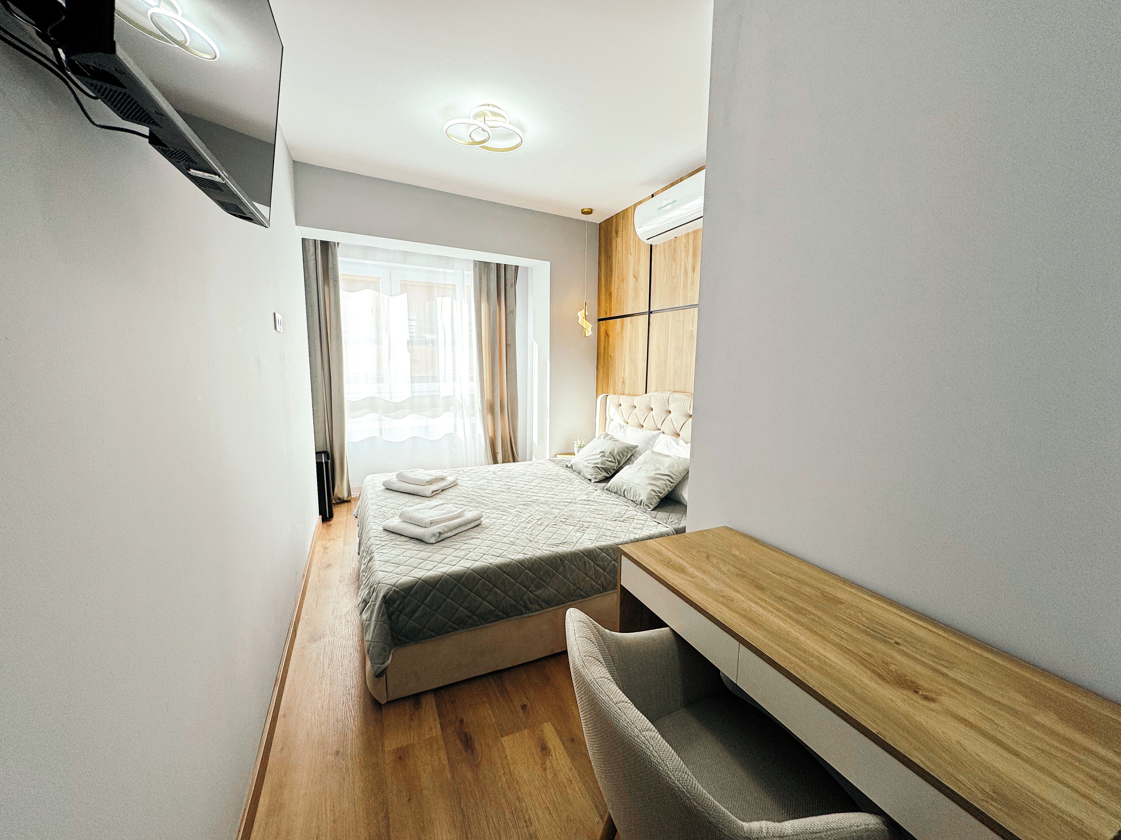 Une chambre à coucher moderne avec un lit, une table de chevet et une chaise.