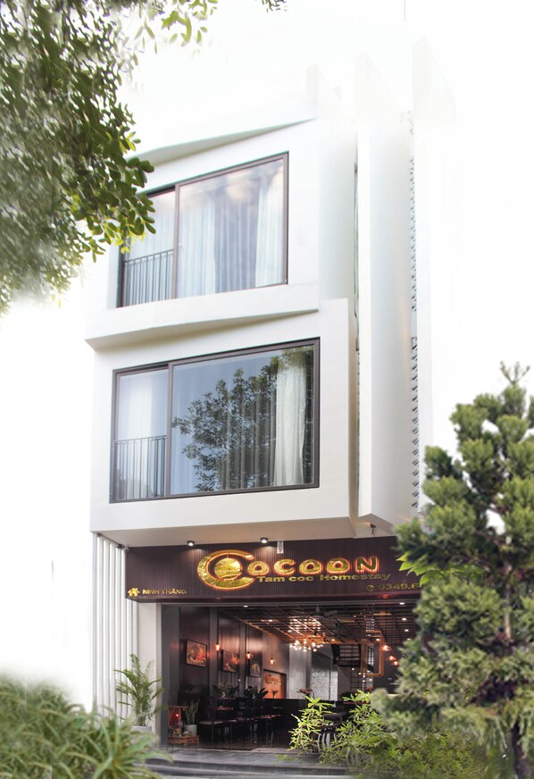 Un moderno edificio de dos pisos con un restaurante llamado "Cocoon" en la planta baja.