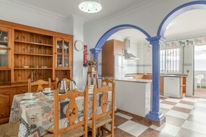 Ein Essbereich mit einem Tisch für vier Personen, Holzsesseln und einer Vitrine.