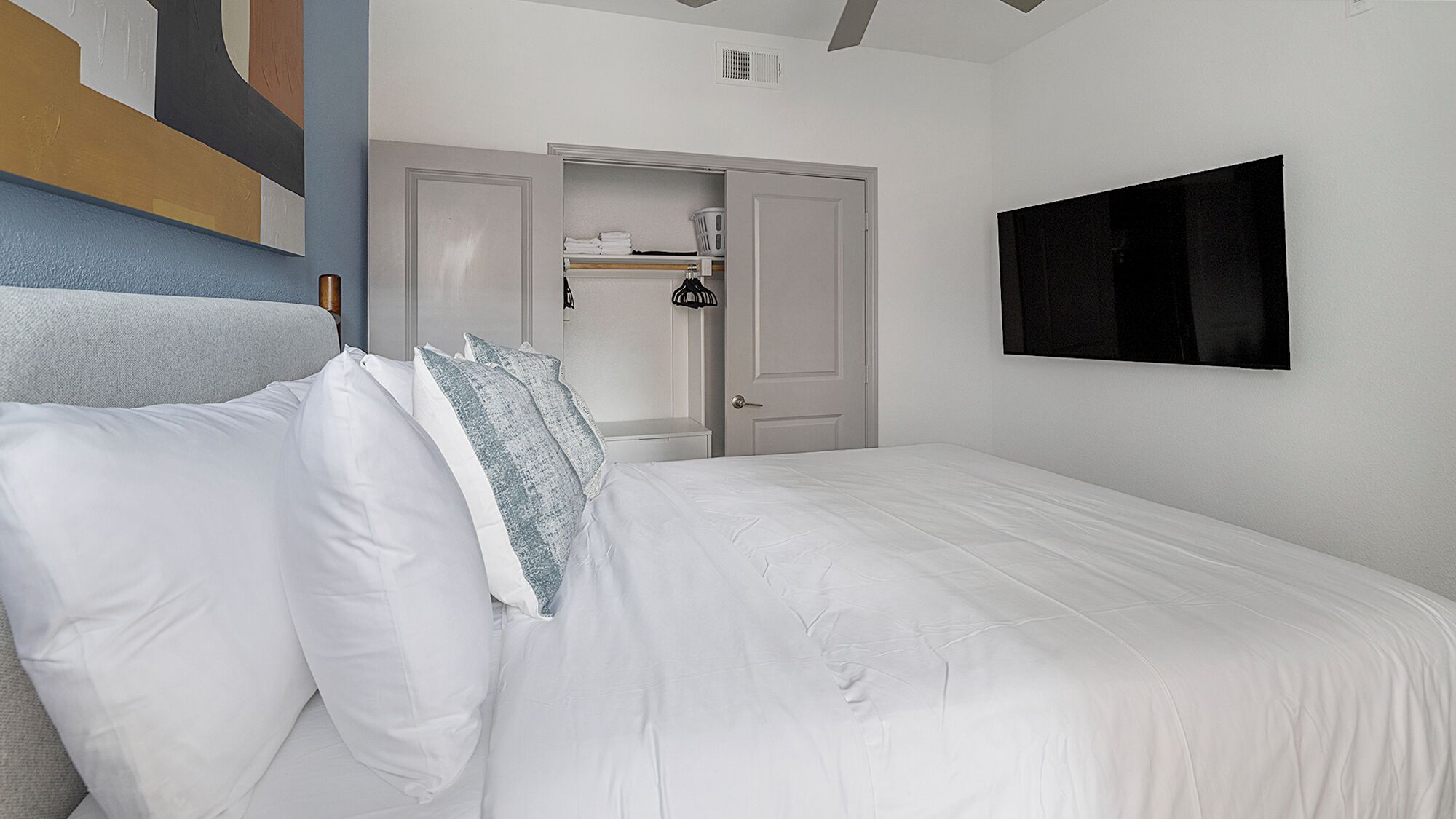 Ein Schlafzimmer mit Bett, Kleiderschrank und Fernseher.