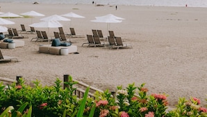 A beach with sun loungers and umbrellas, a clear view of the sea, and a distant bird flying. - Elegant Seibal Penthouse - Vidanta (Nuevo Vallarta)