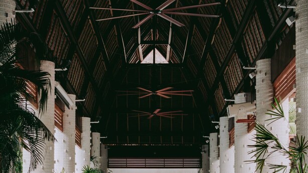 A spacious indoor area with a high ceiling, featuring a central open space with seating and potted plants. - Elegant Seibal Penthouse - Vidanta (Nuevo Vallarta)