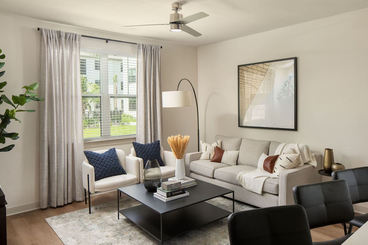 A modern living room with a sofa, armchairs, a coffee table, and a floor lamp.