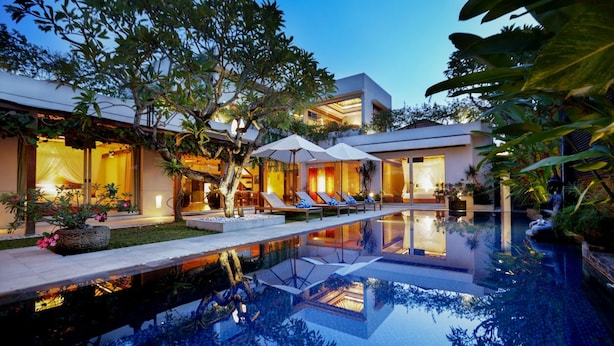 A modern resort with a swimming pool, lounge chairs, and tropical plants. - SPV 8008 · LUXURY JIMBARAN VILLA BY THE BEACH (Bali)